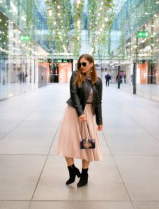 Day Outfit und Abend Look: Rosa Plissee Rock kombiniert zu schwarzer Lederjacke und Stiefeletten mit Blockabsatz